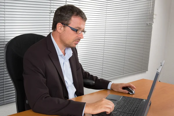 Gestresster Geschäftsmann sitzt am Schreibtisch und macht sich Sorgen — Stockfoto