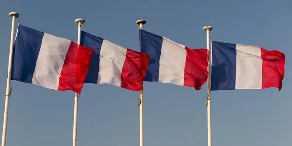 Γαλλικά σημαίες εναντίον μπλε συννεφιασμένο ουρανό. — Φωτογραφία Αρχείου
