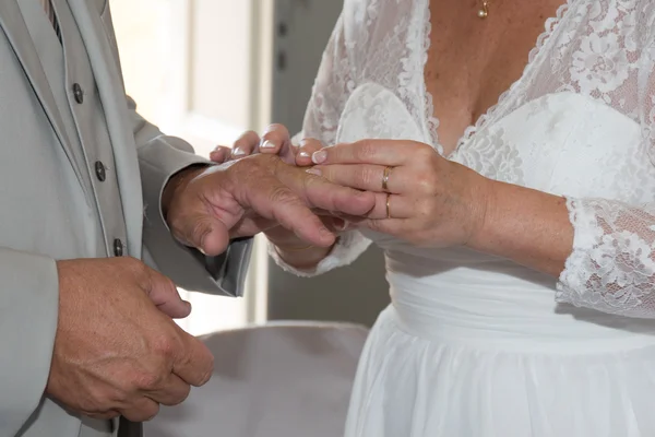 The groom inserting a diamond ring into the bride's finger — Stock Photo, Image