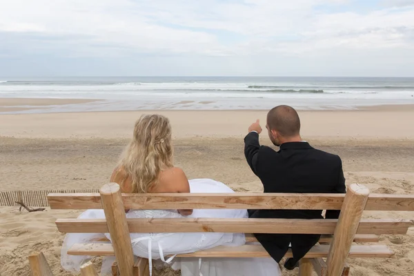 Pareja de boda en el banco frente al mar — Foto de Stock