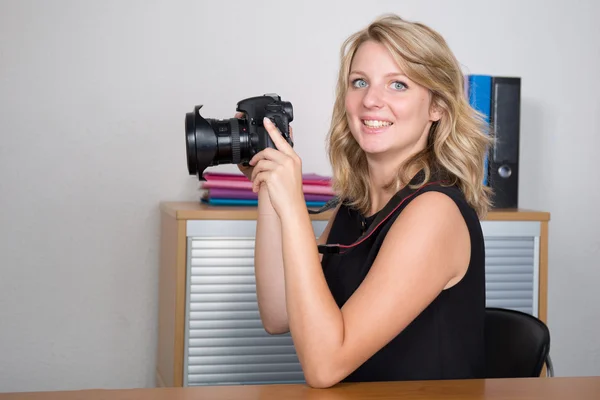 Mulher fotógrafa menina está segurando uma câmera tirando fotos — Fotografia de Stock