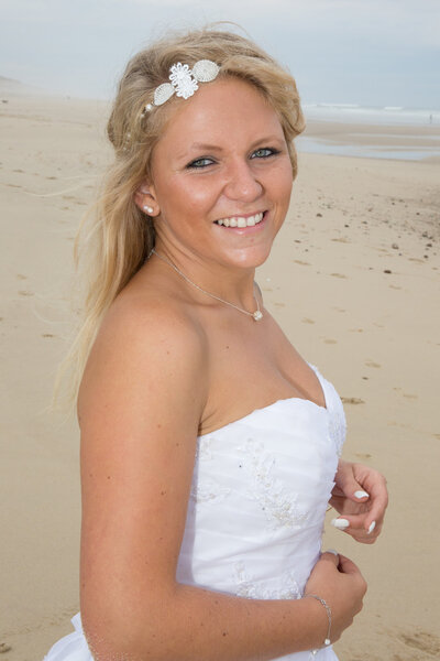 A blond woman in her wedding dress at the beach