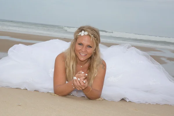 Una mujer rubia en su vestido de novia en la playa — Foto de Stock