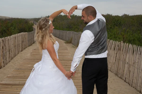 Svatební pár, aby srdce jejich zbraně — Stock fotografie