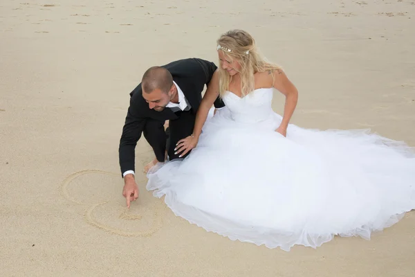 Una sposa attraente e sposo sposarsi sulla spiaggia — Foto Stock