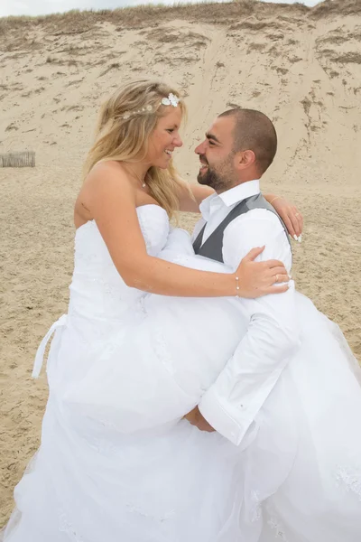 Strand bruiloft: bruid en bruidegom knuffelen door de zee — Stockfoto