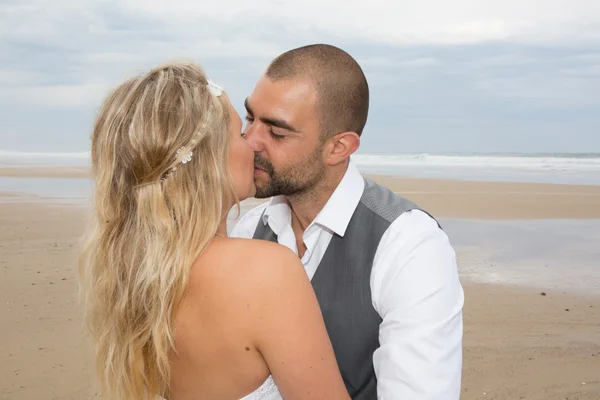 Vackert par på stranden i bröllopsklänning — Stockfoto