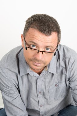 Gözlüklü, yakışıklı adam unhaven ile mavi bir rahat gömlek