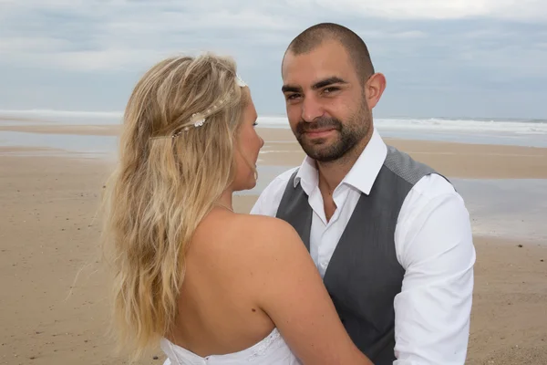 穿着婚纱在海滩上的年轻夫妇 — 图库照片