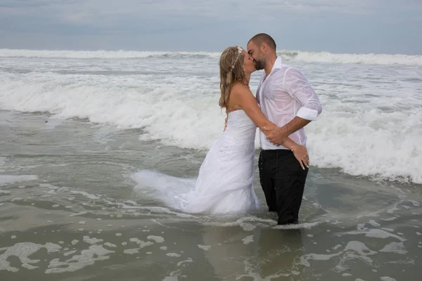 An attractive bride and groom getting married by the beach — Stock Photo, Image