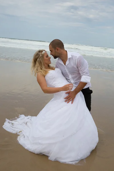 Een aantrekkelijke bruid en bruidegom trouwen aan het strand — Stockfoto