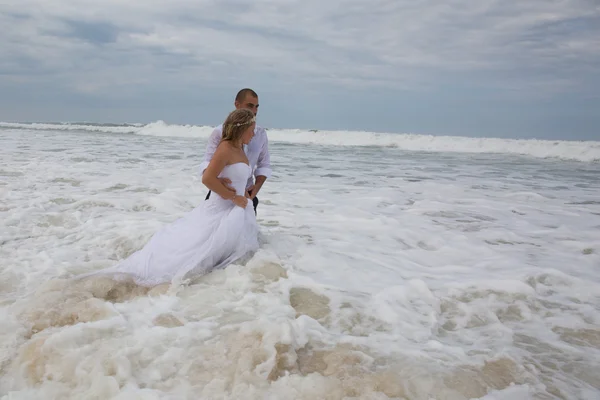 Casamento casal na praia com uma roupa de casamento — Fotografia de Stock