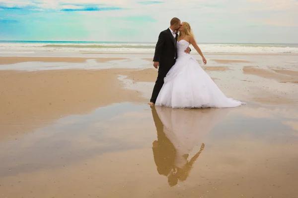 Gelukkig en een prachtig bruidspaar in een tropische zee — Stockfoto