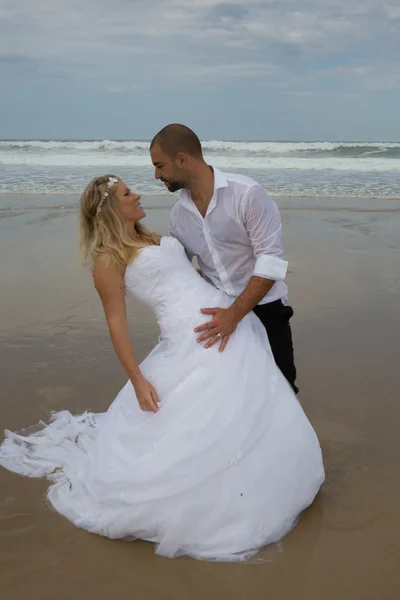 Glückliches frisch vermähltes Paar am Strand — Stockfoto