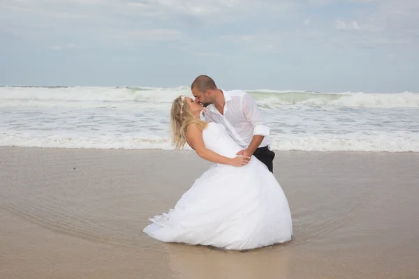 Glückliches frisch vermähltes Paar am Strand — Stockfoto