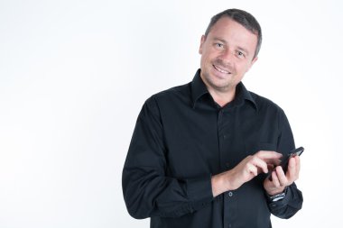 Gülümseyen genç adam akıllı telefonuna bakarken mesaj beyaz arka planda izole edilmiş.