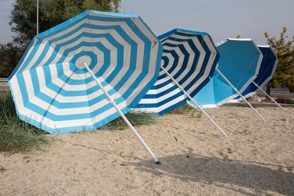 Scena na plaży. Kolorowe parasole leżaki — Zdjęcie stockowe