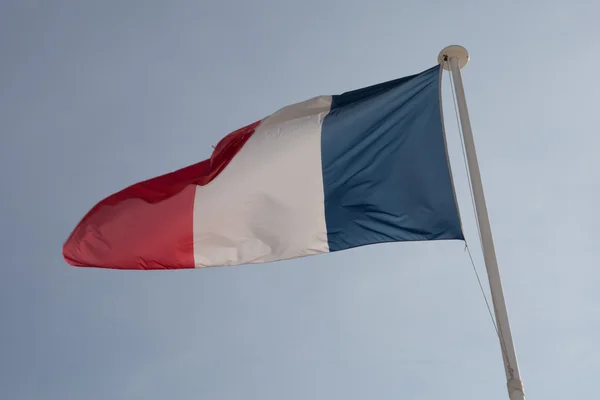 A bandeira francesa contra o céu azul nublado . — Fotografia de Stock