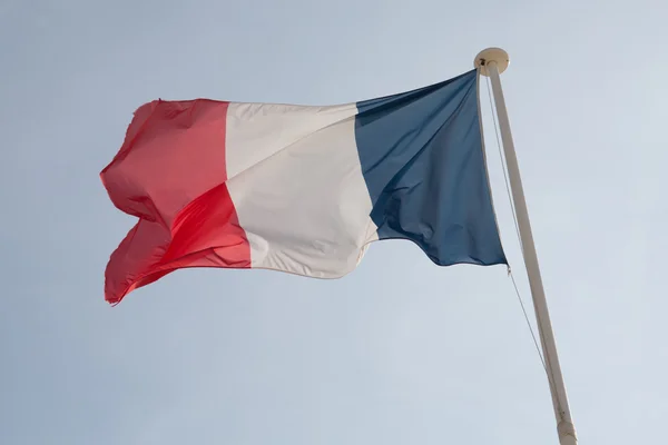 A bandeira francesa contra o céu azul nublado . — Fotografia de Stock