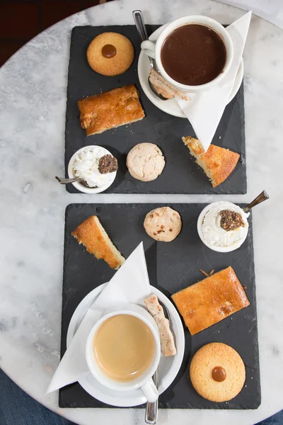 Filiżankę kawy i smaczne ciasteczka na szarym tle — Zdjęcie stockowe