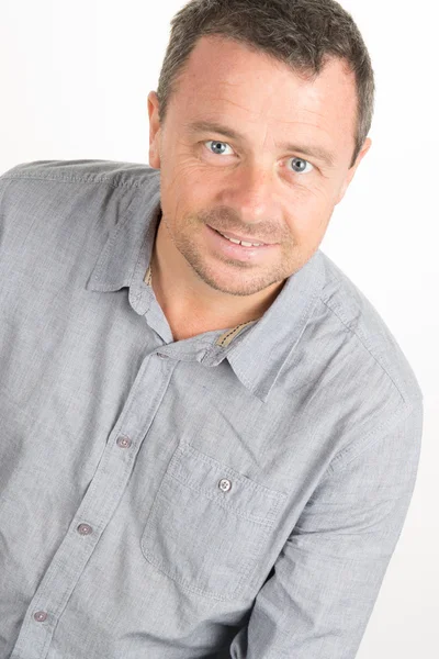 Business man in blue shirt looking at camera standing against white background — Stock Photo, Image