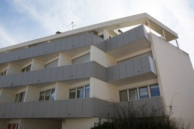 Yeni inşa edilmiş modern blok daireler birkaç bulut ile mavi gökyüzü altında