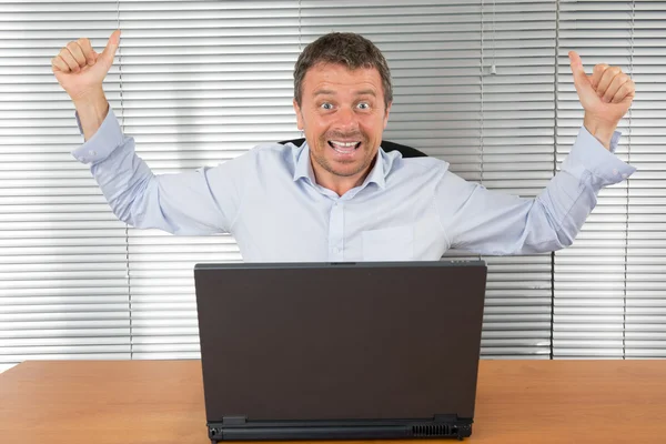Excited businessman with arms up