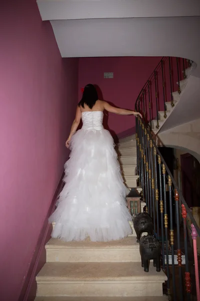 Schöne Braut im Brautkleid mit langer Schleppe stehend — Stockfoto