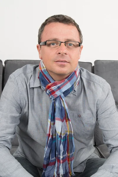 Man sitting on his couch at home — Stock Photo, Image