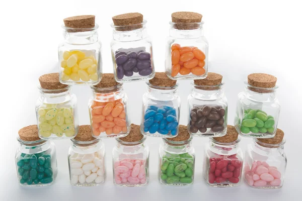 Klarglasdose mit Bonbons und bunten Gelee-Bohnen aus Glas verschüttet — Stockfoto