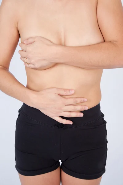 Nahaufnahme, oben ohne Frauenkörper, der ihre Brust mit der Hand bedeckt — Stockfoto