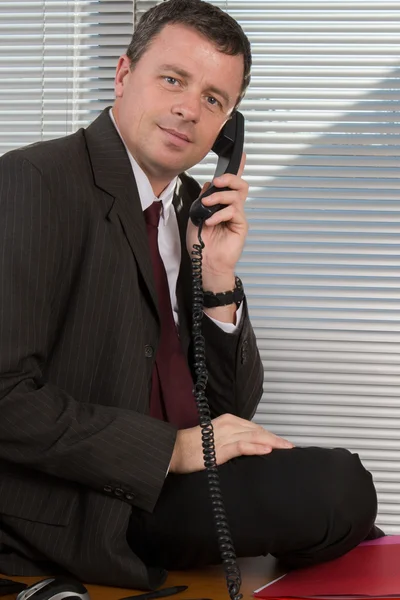 ビジネスマンはオフィスで携帯電話で話しています — ストック写真