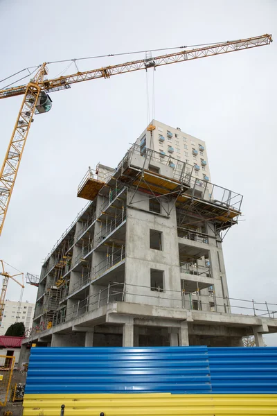 Building and cranes under construction against grey sky — Stock Photo, Image