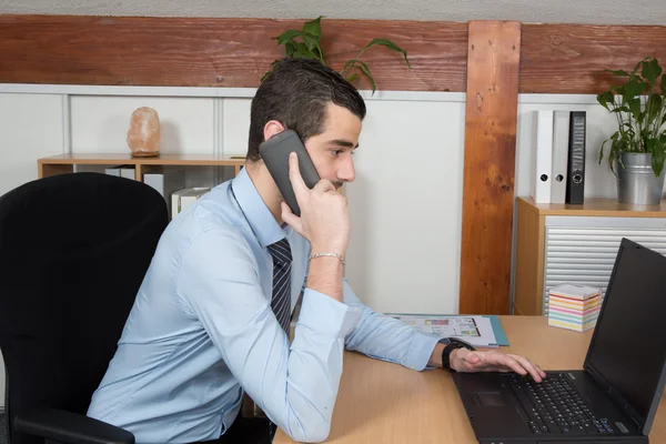 Arbeitsmomente. schöner junger Mann mit Bart in Hemd und Krawatte bei der Arbeit an seinem Arbeitsplatz — Stockfoto