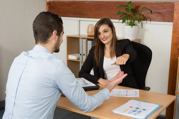 Fastigheter agent ger nycklar till ny fastighetsägare — Stockfoto