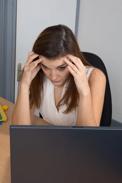 Mladá žena trpí bolestmi hlavy a migréna čelí Laptop na stole. izolovaný — Stock fotografie