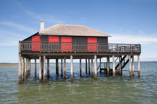 Casa tropical de madeira em palafitas sobre a água do mar — Fotografia de Stock