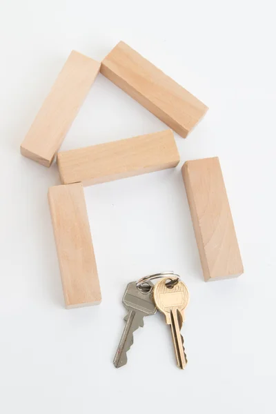 Ein kleines Holzhaus und Schlüssel isoliert auf weiß — Stockfoto