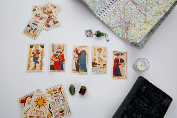 Péndulo verde sobre una mesa con carta astrológica y cartas de tarots —  Fotos de Stock