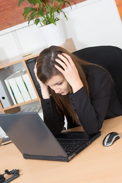 Onu laptop bir ofiste yazarak sıkılmış esmer iş kadını — Stok fotoğraf