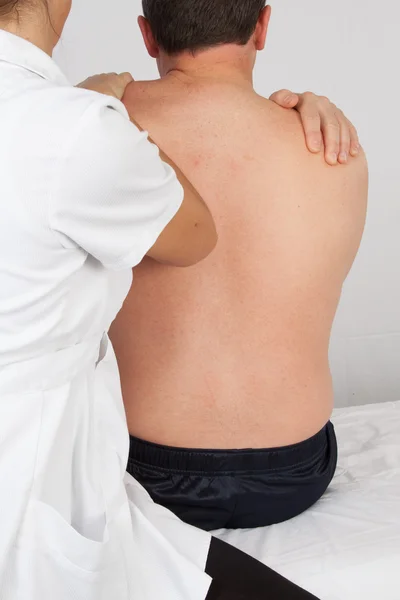 Man op een massagetafel heeft zijn laag terug massaged — Stockfoto