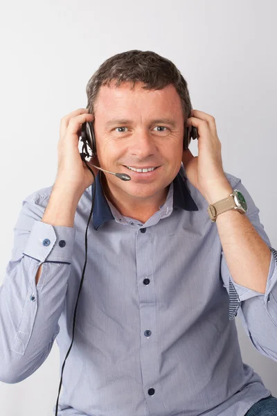 Šťastný muž pracuje v callcenter, pomocí headsetu — Stock fotografie