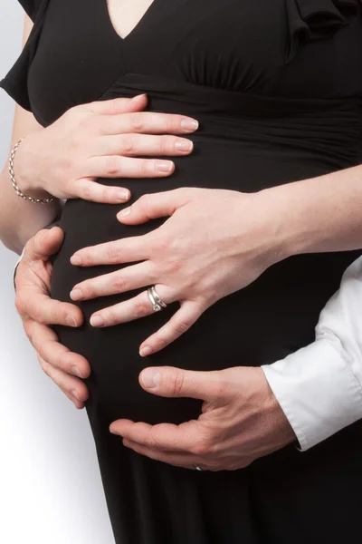 Young couple expecting a baby with hands on the belly — Stock Photo, Image