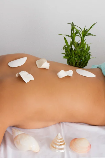 Close up de uma morena fofa deitada em uma mesa de massagem em um spa — Fotografia de Stock