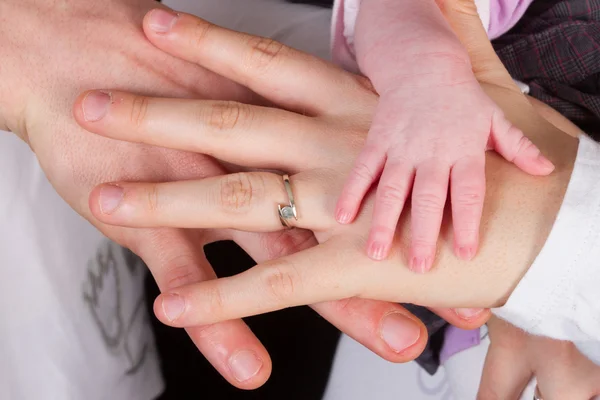 赤ちゃんの手が黒の背景の下で母の手を握って — ストック写真
