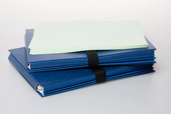 Folders full of business papers: bills, accounts receivable,invoices,receipts,etc. Blue folder with a business paperwork and red tape. — Stock Photo, Image