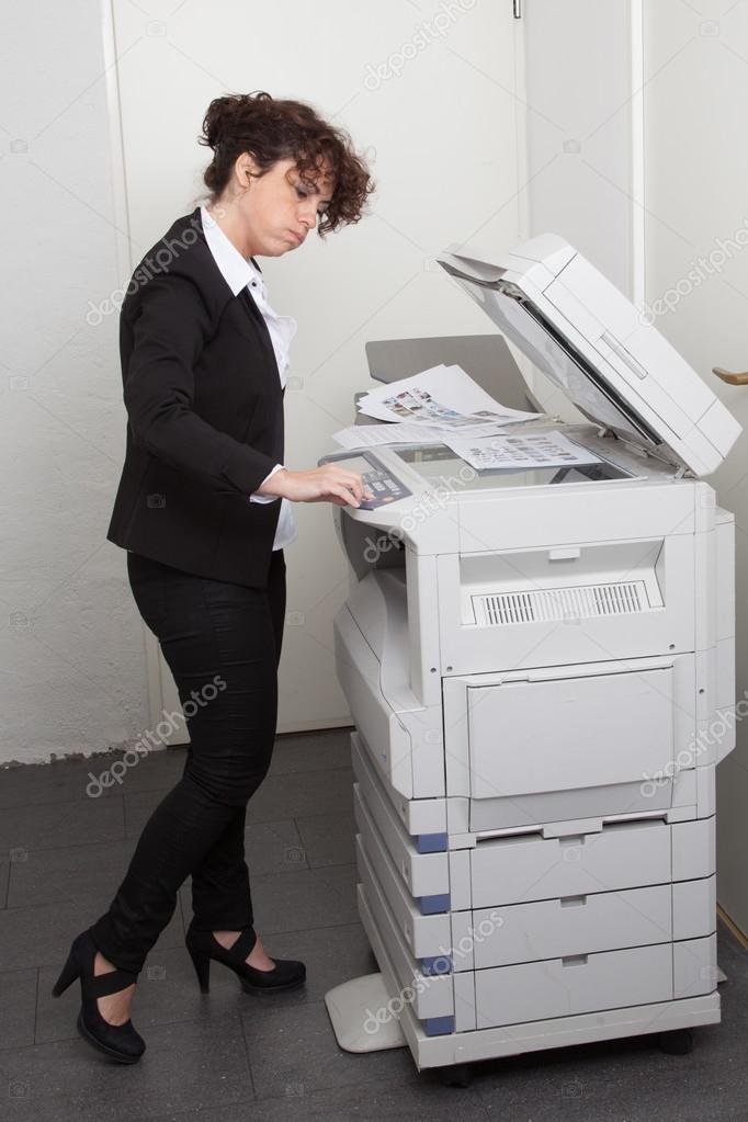 Woman copying notes on a coin operated photocopier — Stock Photo