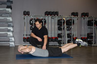 Eğitmen fitness salonunda egzersiz mat adam ile çalışma