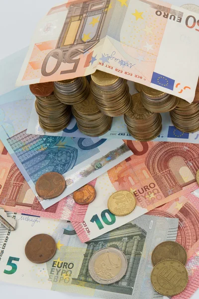 Casa feita de notas e moedas de euro na mesa — Fotografia de Stock