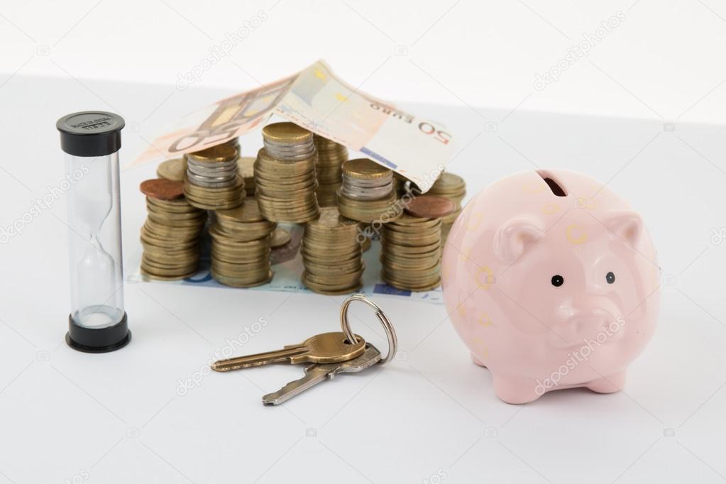 Small House and Piggy Bank with Stacks of money  Isolated on a White Background.